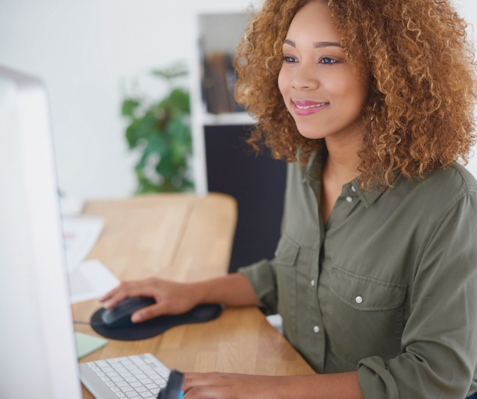 Woman smiles sat at her computer