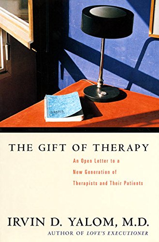 Book cover showing therapy consulting room desk with book and lamp. The Gift of Therapy by Irvin Yalom