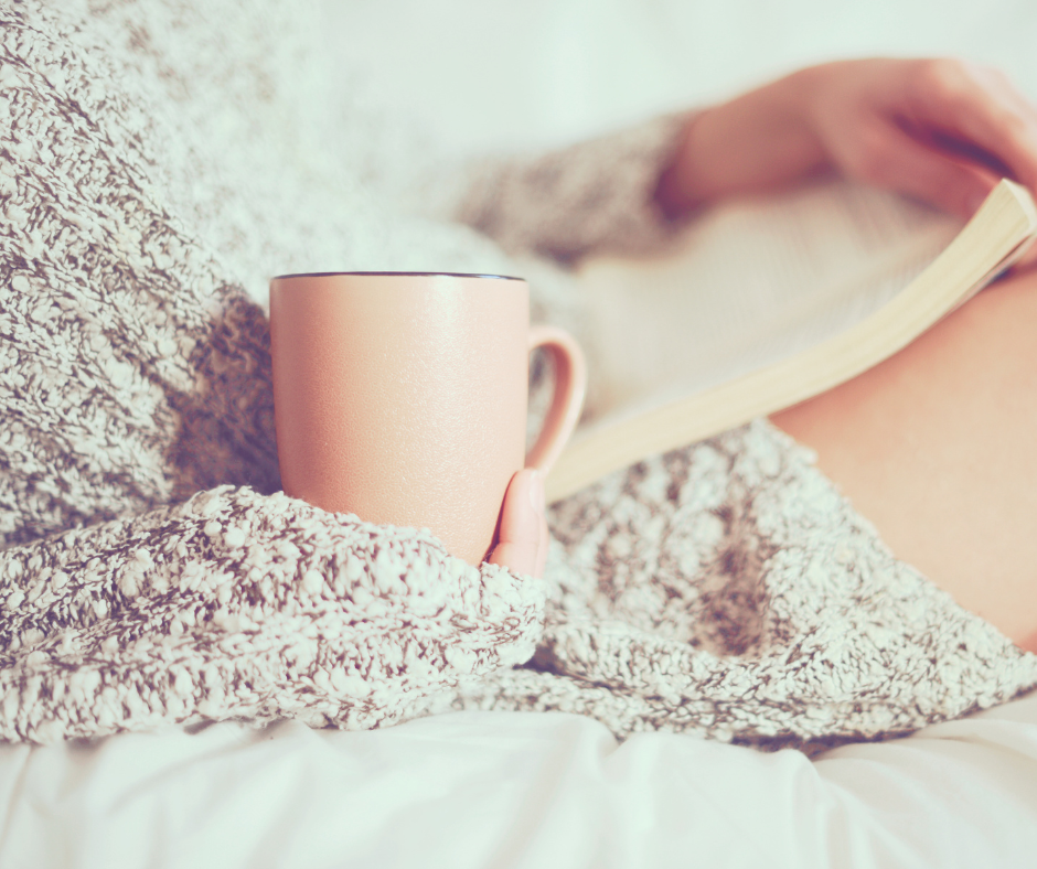 Close of woman reading a book while having a cuppa