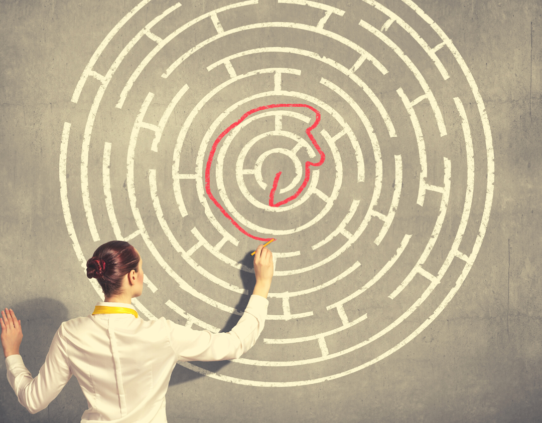 Woman tries to solve a maze drawn on a blackboard