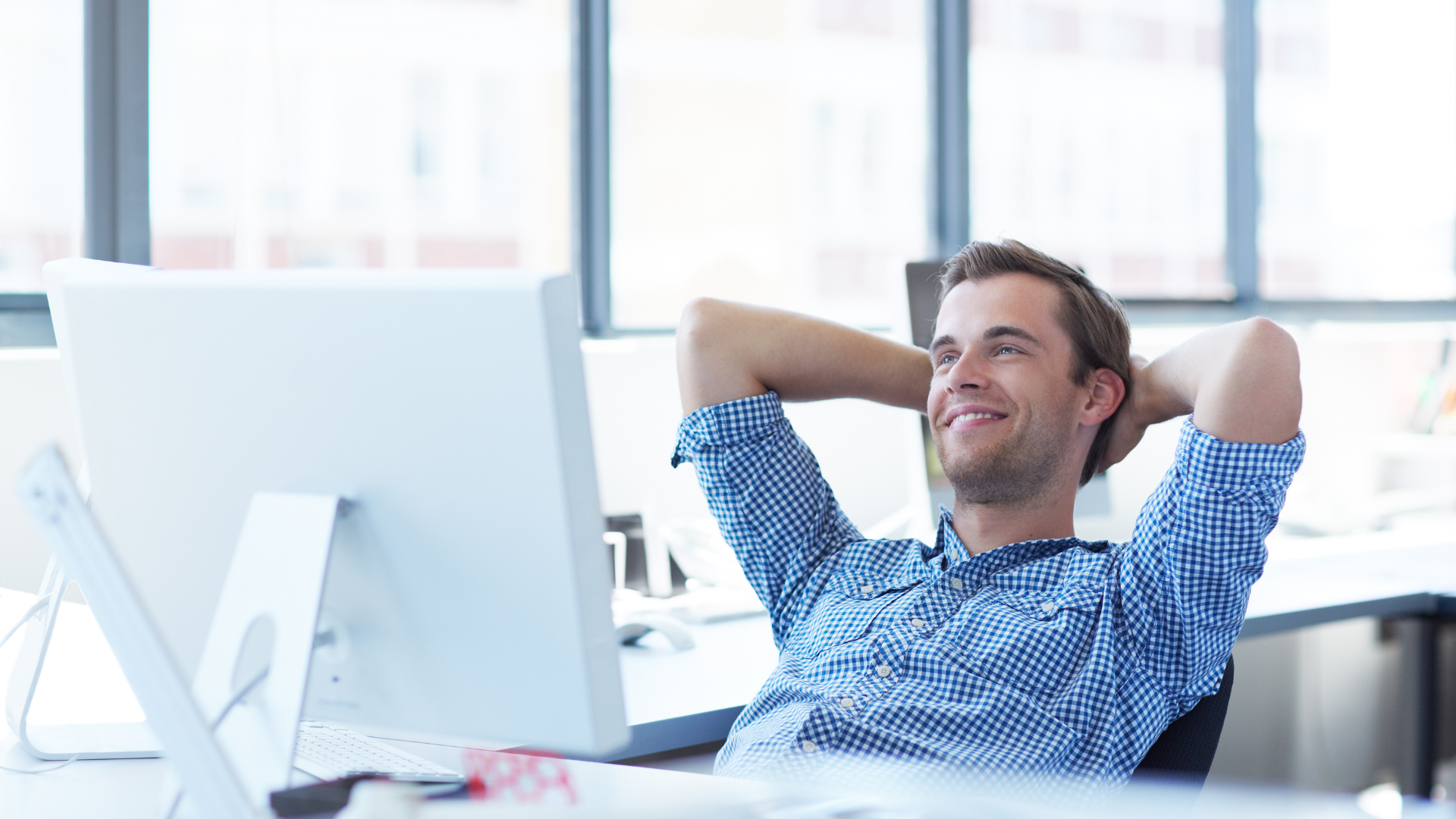 Male therapist reclines in chair at his desk