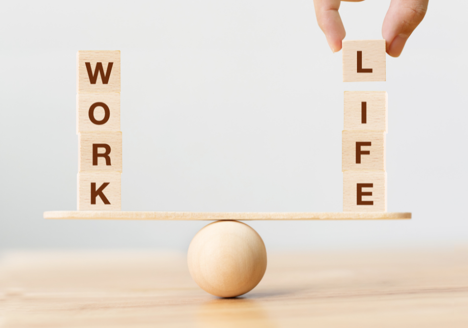 Wooden blocks on a balanced see-saw spelling out 'work' on one side and 'life' on the other