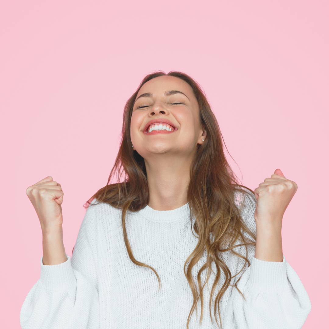 Close up of a happy woman, celebrating against a pink background