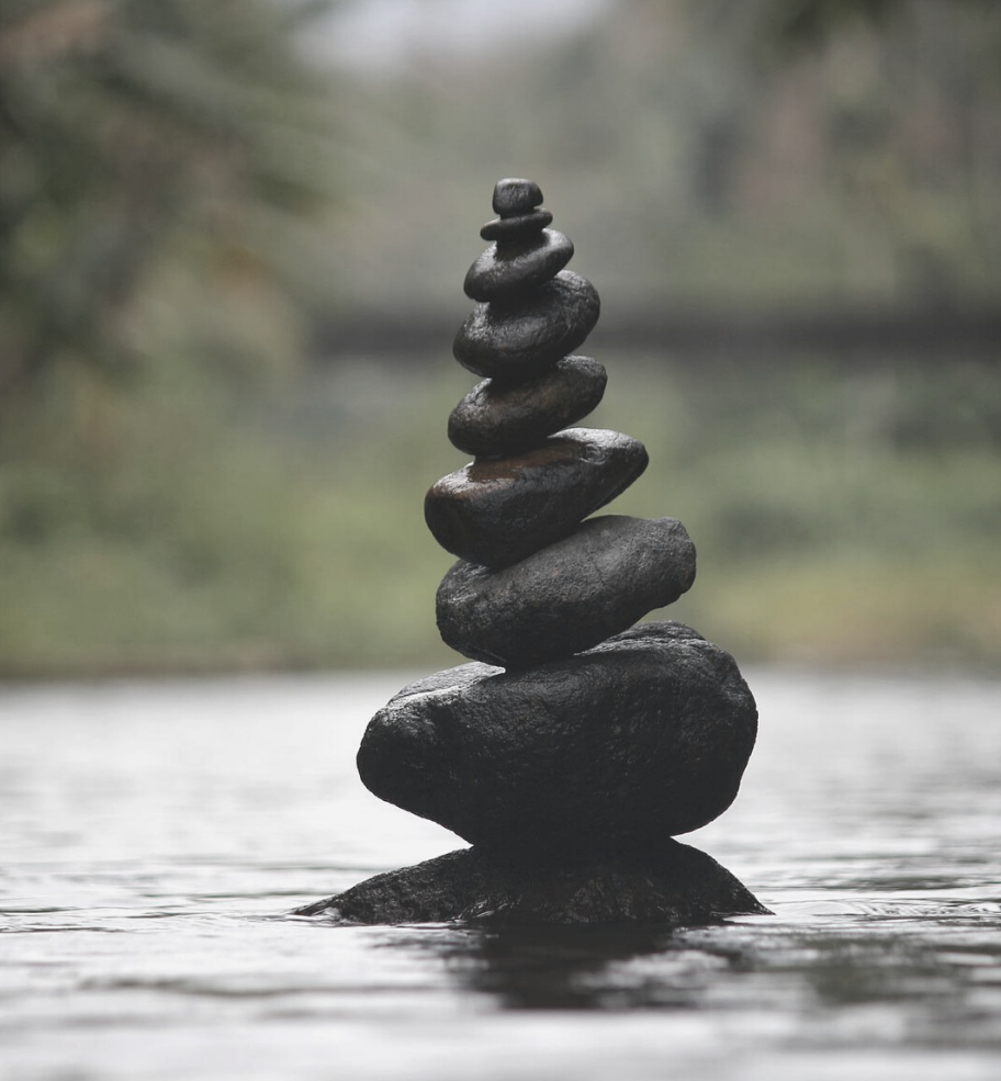 Image of meditation pebble tower on water to symbolise stress relief and relaxation