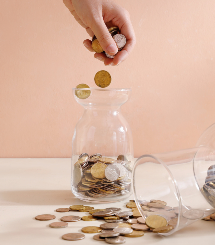 Money jars with  coins in against a pink background
