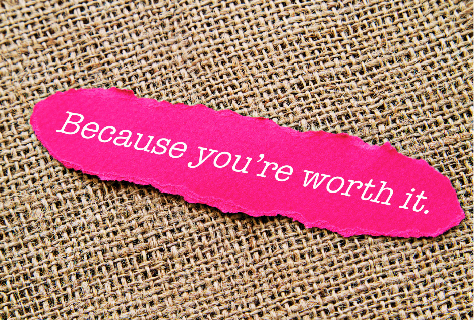 Close up of a pink piece of paper with Because you're worth it written in white 