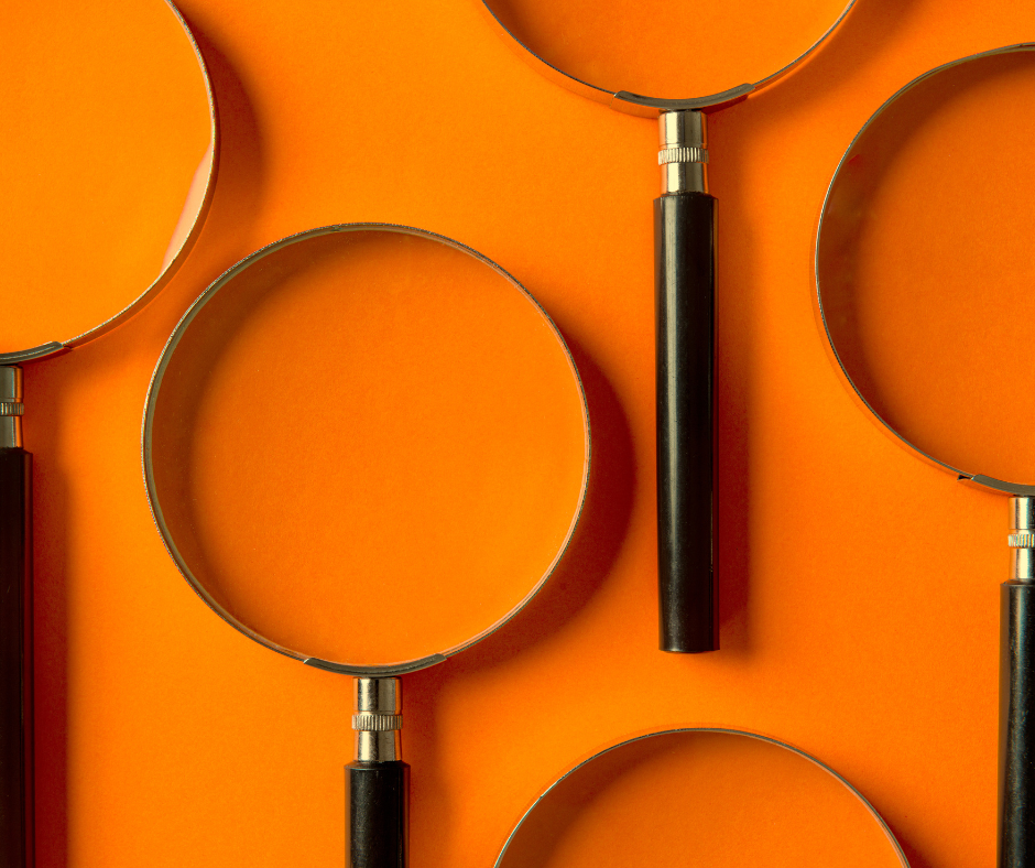 Close up of magnifying glasses against an orange background