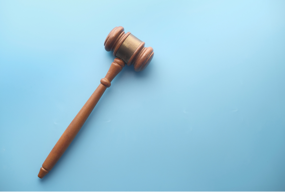 Photograph of a Judge's gavel on top of a bible on a wooden table