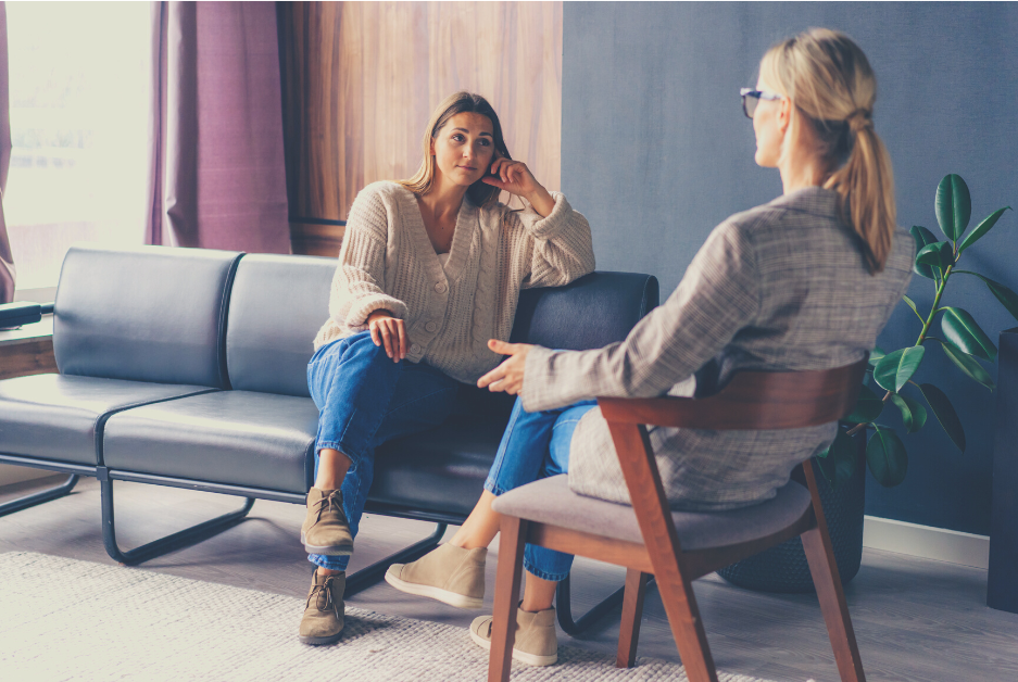 Photograph of female therapist talking with a young, female counselling client in a consulting room