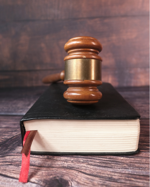 A wooden Judge's gavel lies at 45 degrees against a blue background