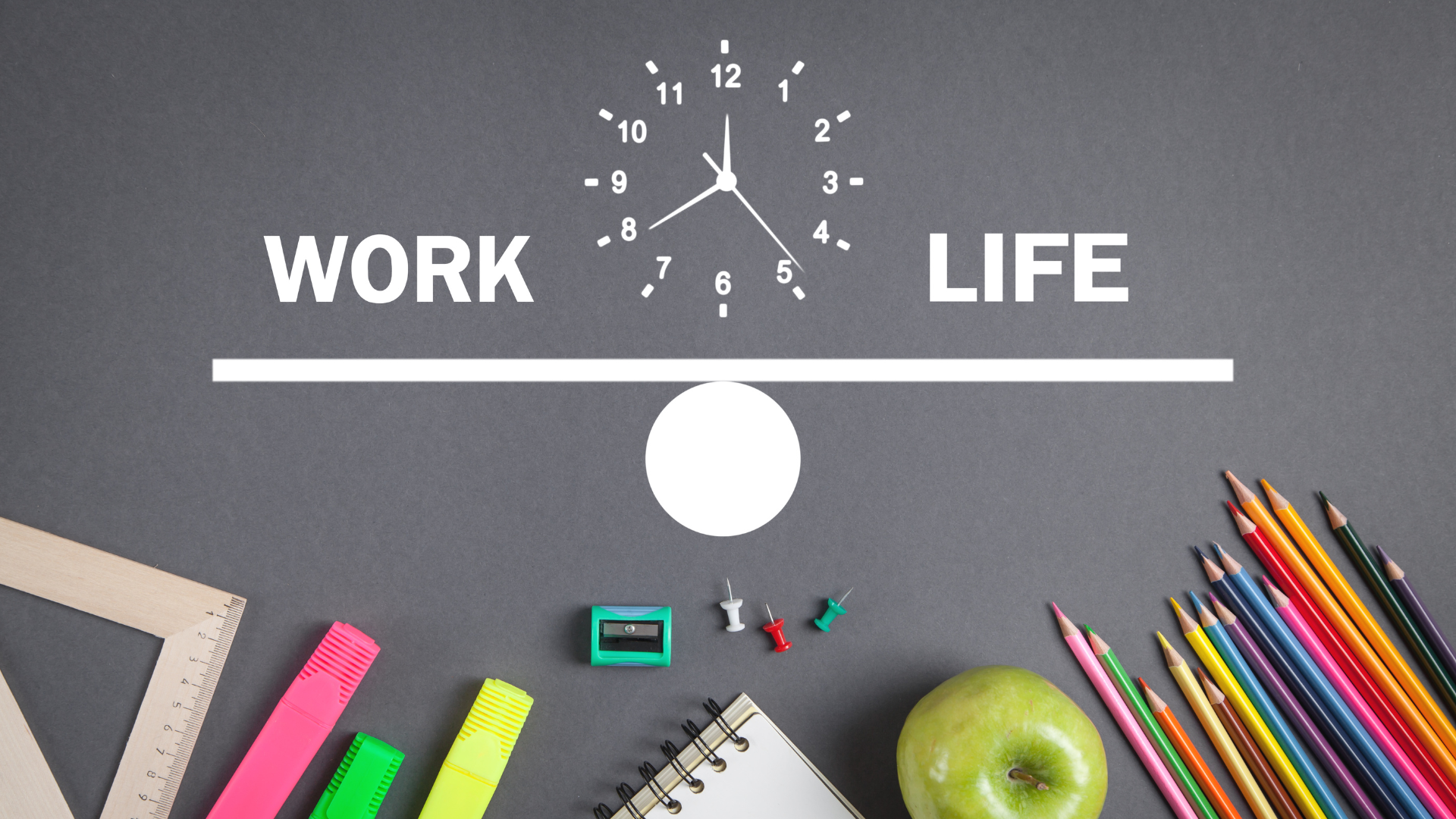 Image of stationary on a black desk with a white clock and a work life balance icon