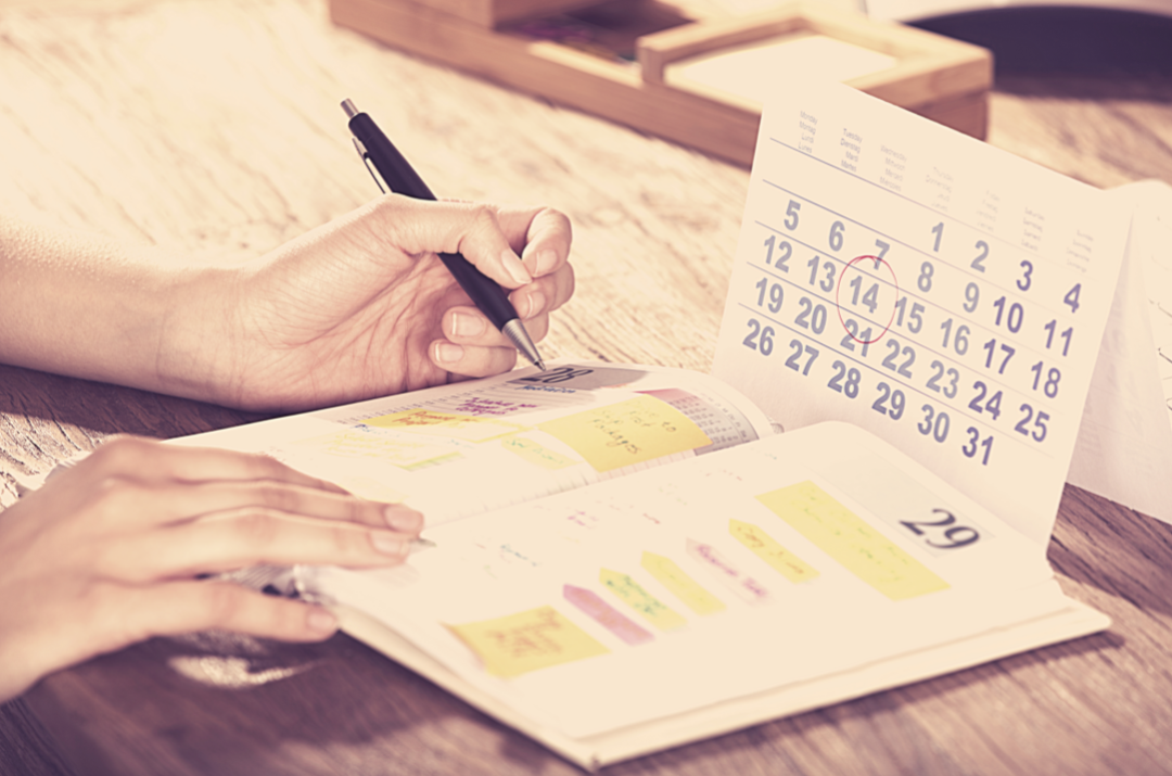 Close up of a therapist managing their clinical diary without using appointment scheduling software. A paper diary and calendar.