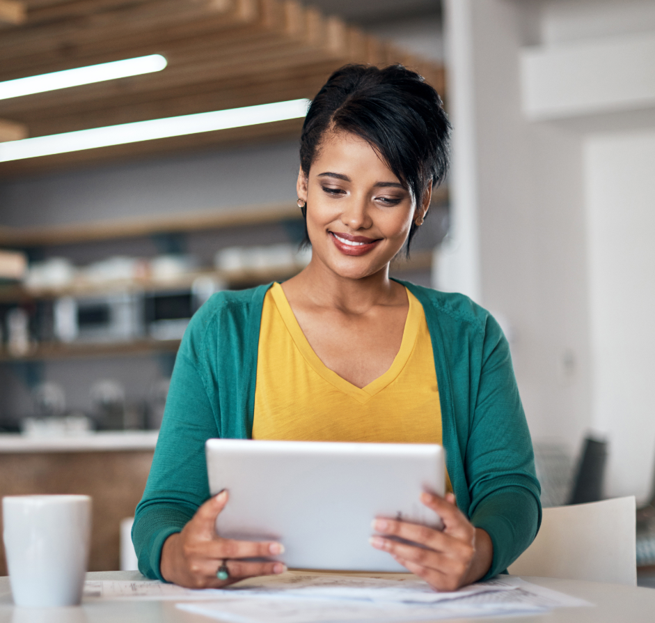 Happy female therapist in yellow and green using diary management software on her tablet