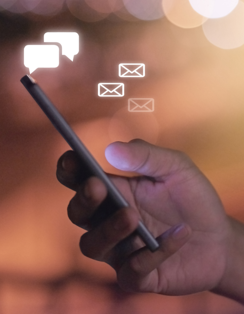 Close up of a hand holding a mobile phone with icons showing messages being sent and received