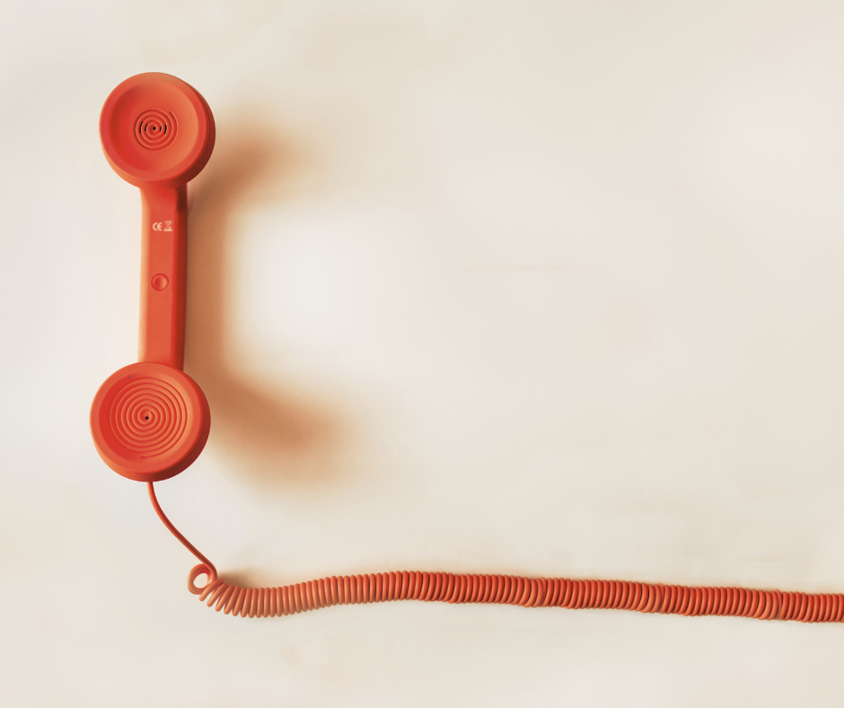 Close up of a red vintage telephone receiver and cord.