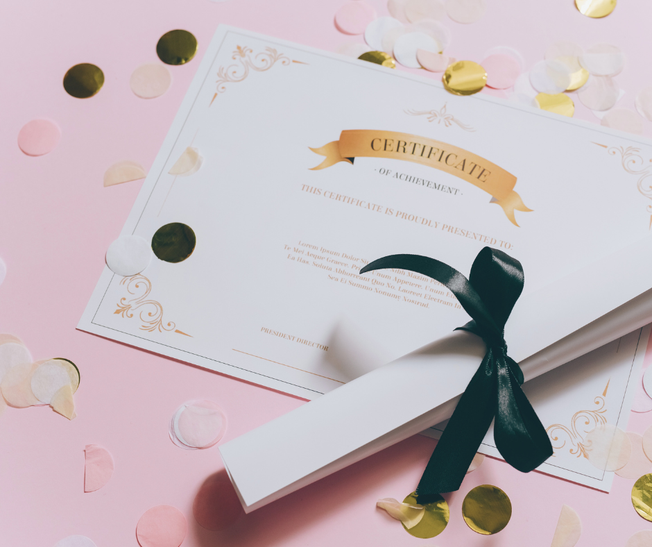 Close up of a counselling diploma with graduation confetti against a pink background