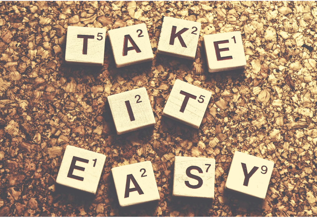 Scrabble tiles against a cork background spelling out the phrase Take It Easy.Symbolising how practice management software makes it so much easier to run your counselling business