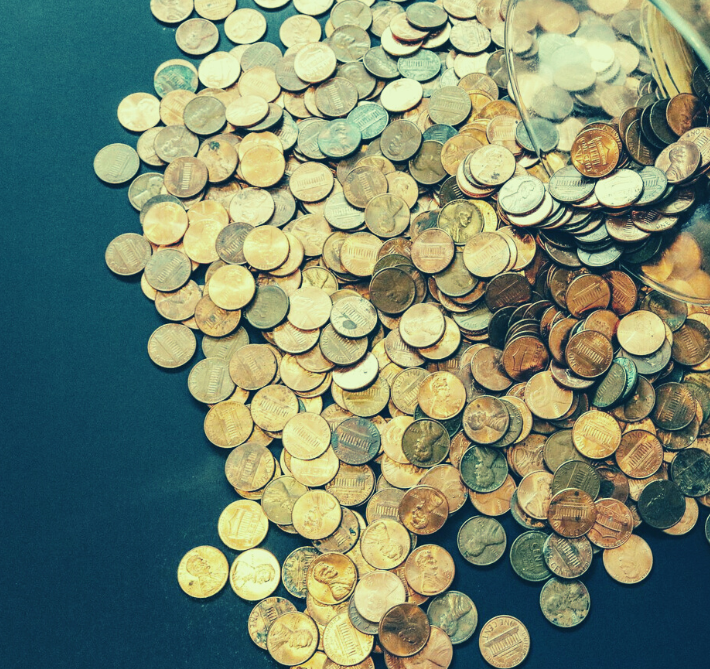 Copper coins spilling out from a jar