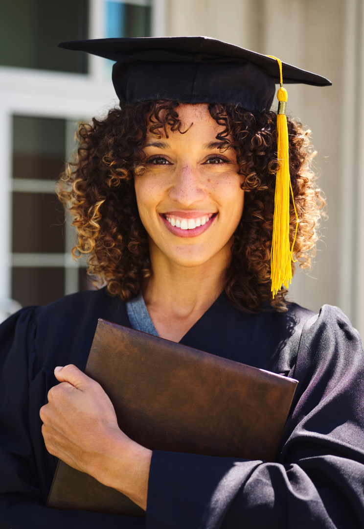 Female counselling course graduate in black gown & hat holding her counselling qualification certificate